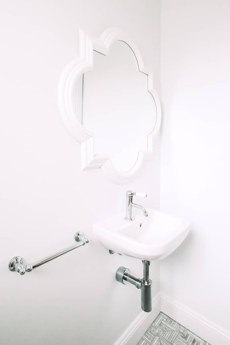 Wall-vanity-in-white-bathroom-with-exposed-pipes