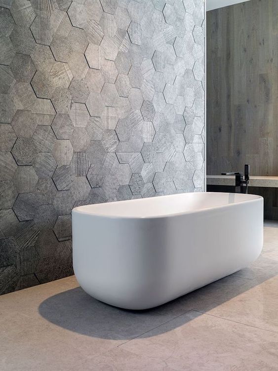 Hexagonal Drama wall tiling in a bathroom with a bath