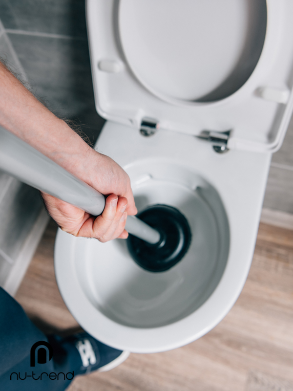 Blocked drains photo plumber using plunger to unblock a toilet in Sydney